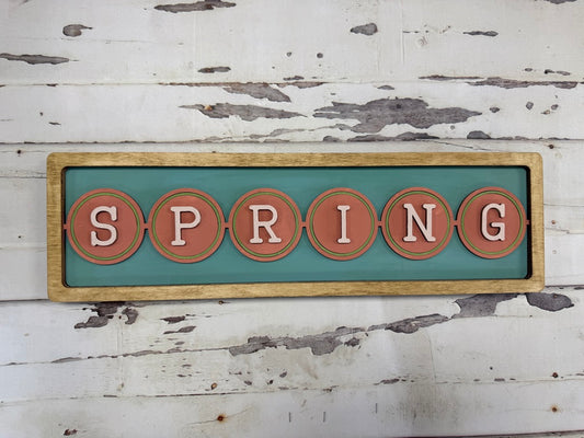 Decorative sign with 'SPRING' on a rustic wooden background