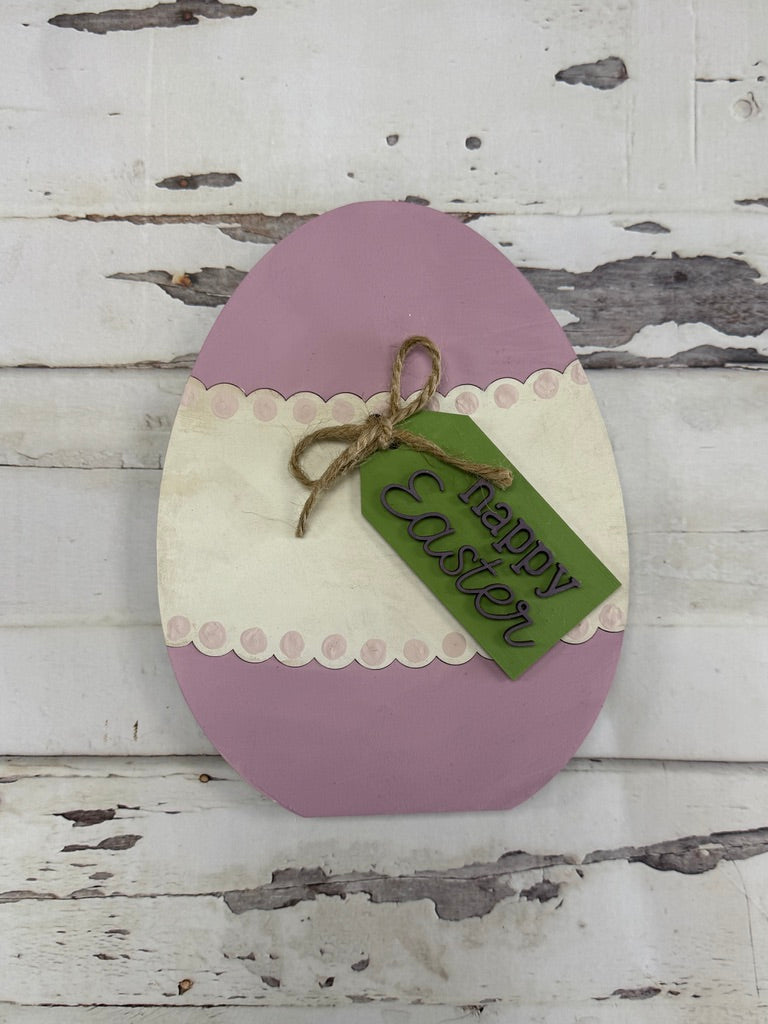 Decorative Easter egg with a 'Happy Easter' tag on a wooden background
